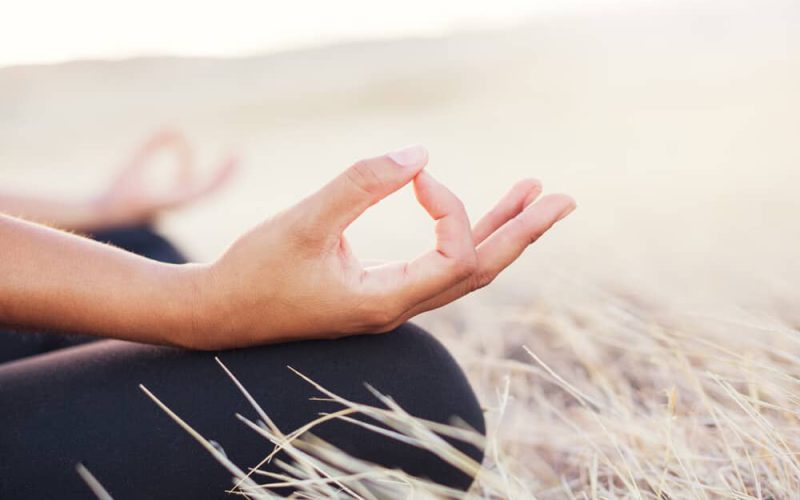 Woman meditating practicing yoga outdoors